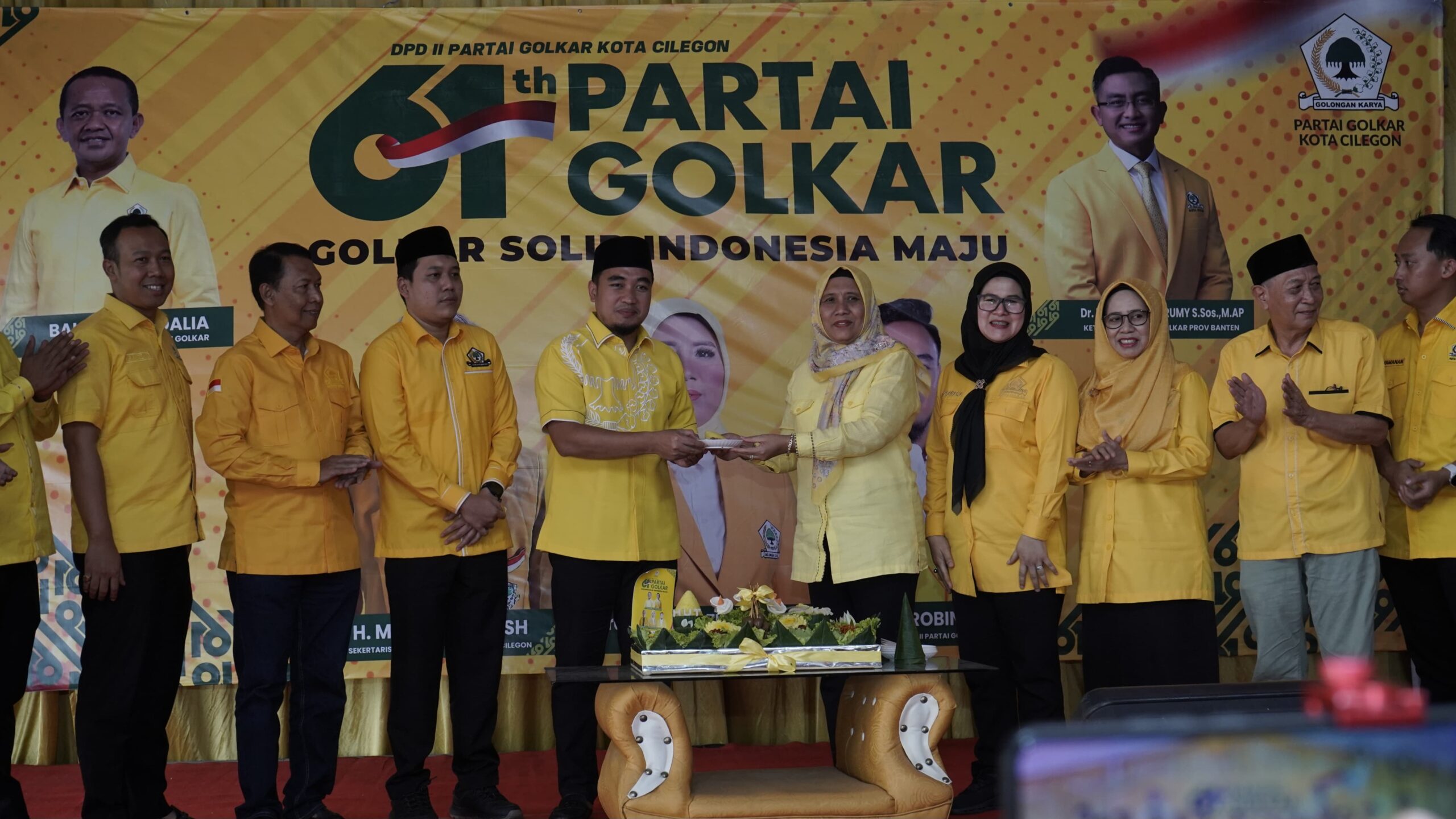 Ketua DPD Golkar Cilegon Ratu Ati Marliati saat memberikan potongan tumpeng kepada kader Golkar yang juga Wali Kota Cilegon Robinsar pada peringatan HUT ke 61 tahun Partai Golkar.