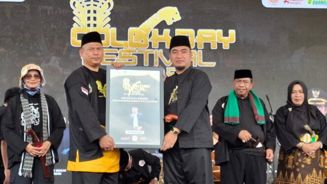 
					Ketua IPSI Kota Cilegon Abdul Rojak berikan piagam penghargaan kepada Wali Kota Cilegon Robinsar sebagai Tokoh Pendekar Muda Cilegon pada Golok Day Award 2025.